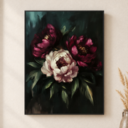 Framed canvas wall art depicting large burgundy peonies and a pale pink bloom among dark leaves on a neutral wall