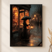 Framed canvas wall art depicting a woman beneath an umbrella outside a warmly lit city storefront at dusk on a neutral wall