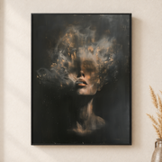 Framed canvas wall art depicting a woman's face emerging through gray smoke and shadow with soft floral shapes on a neutral wall