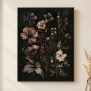 Framed canvas wall art depicting soft blush, ivory, and mauve wildflowers arranged vertically against black on a neutral wall