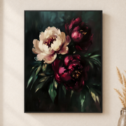 Framed canvas wall art depicting cream and burgundy peony flowers with deep green leaves against a nearly black background on a neutral wall