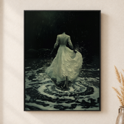 Framed canvas wall art depicting a woman in a pale flowing gown surrounded by dark rippling water on a neutral wall